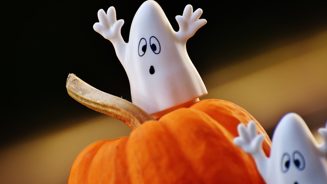 Игрушечные призраки на тыкве на Хэллоуин 