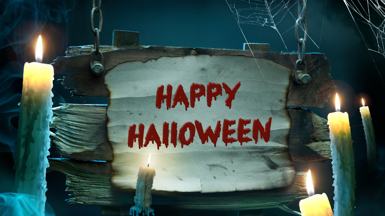 Страшная надпись Счастливого Хэллоуина на деревянной табличке со свечами