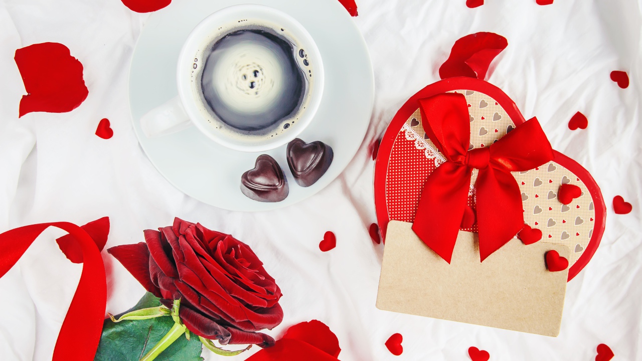 Чашка кофе на столе с коробкой в форме сердца и красной розой для любимой