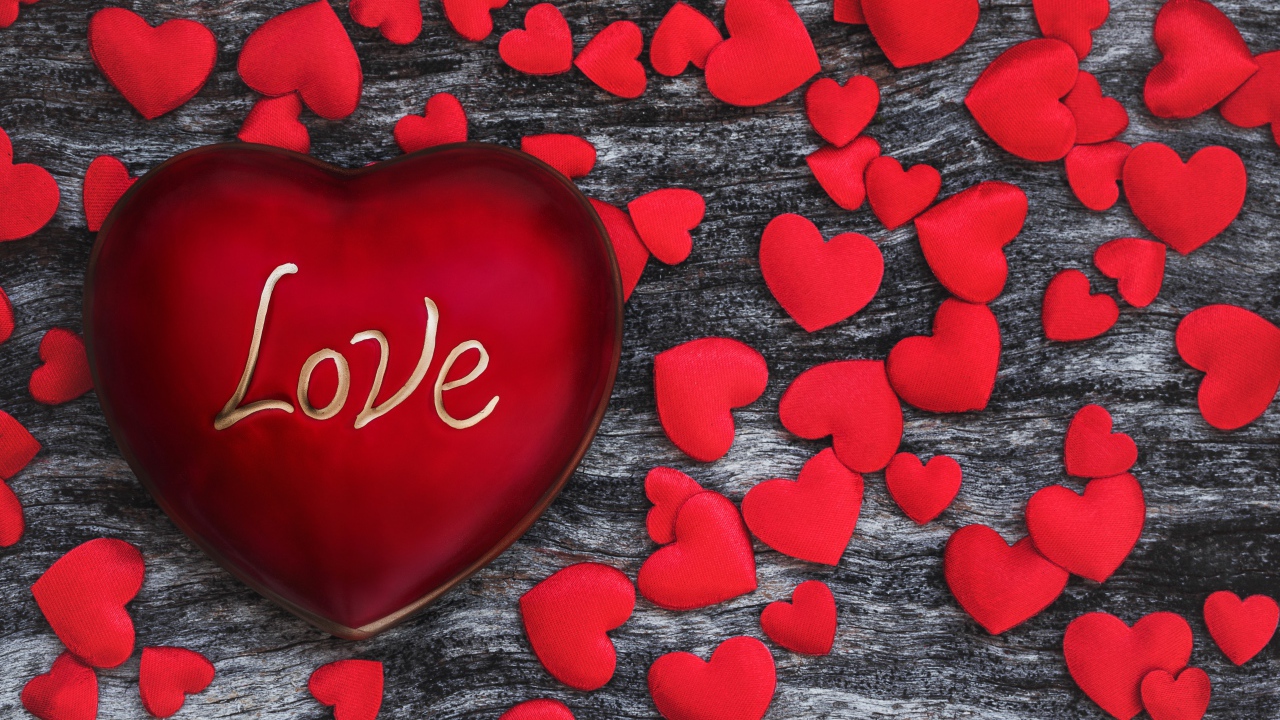 Большое красное сердце на деревянном фоне с маленькими сердечками