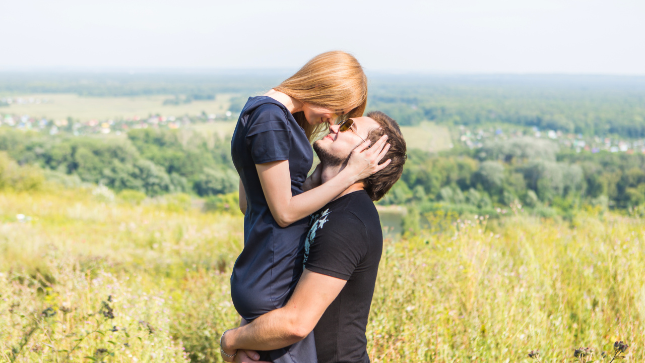 Влюбленная пара обнимается на поле 