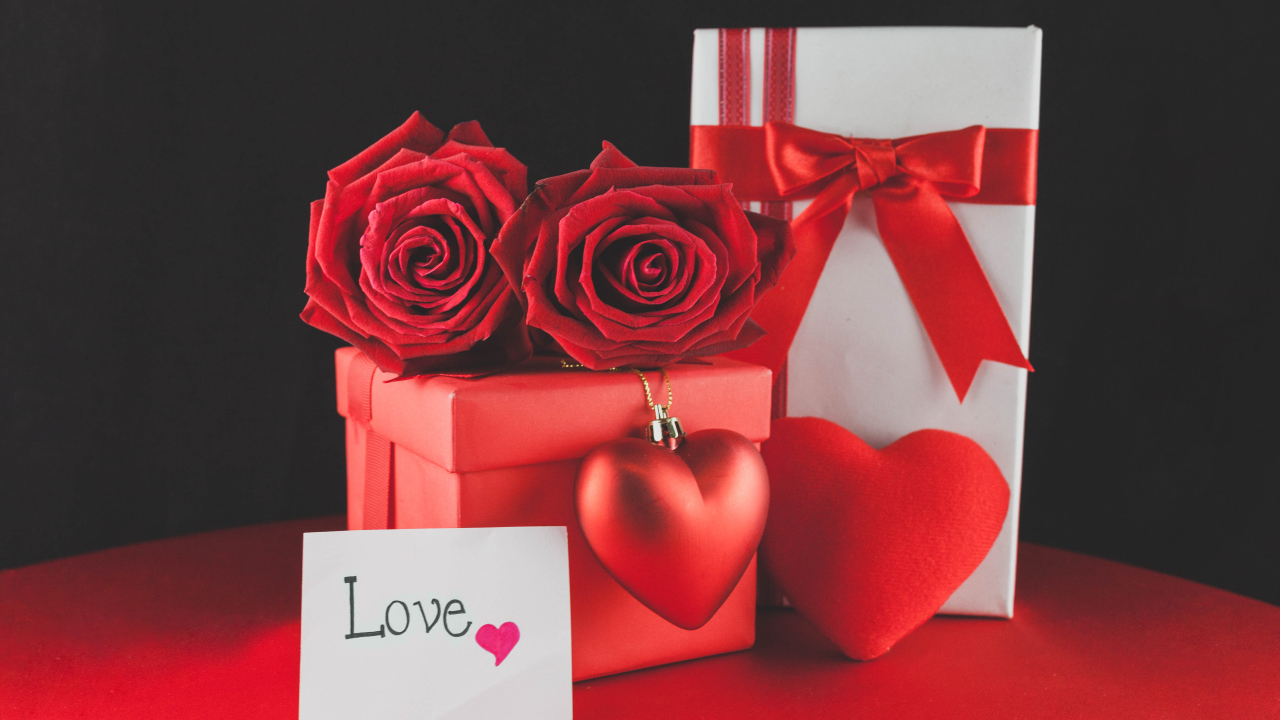 Коробки с подарками на столе с красными розами и сердцем