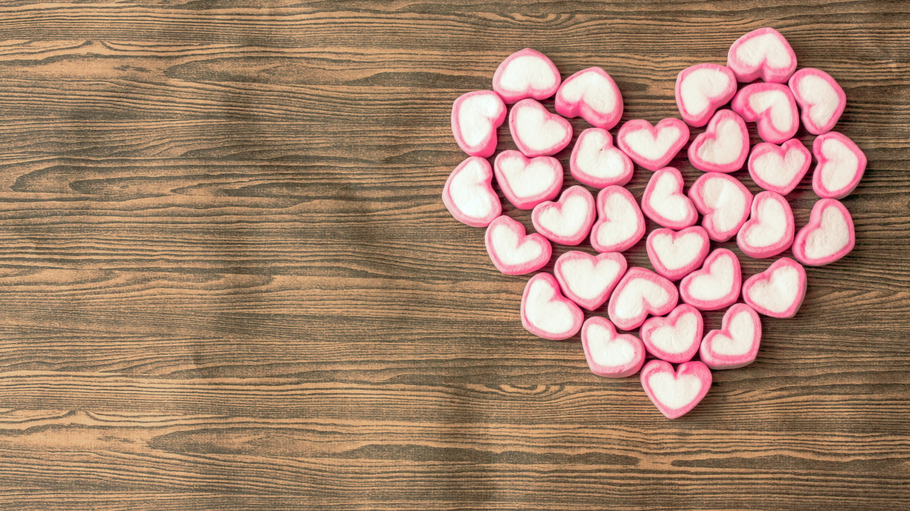 Сердце из конфет на деревянном столе