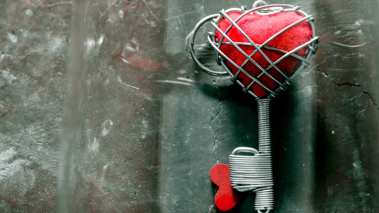 Ключ с красным сердцем на сером столе