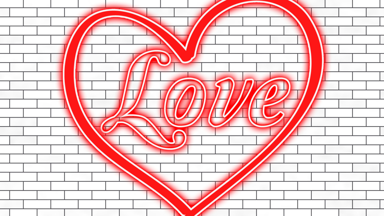 Красное сердце с надписью Любовь на кирпичной стене