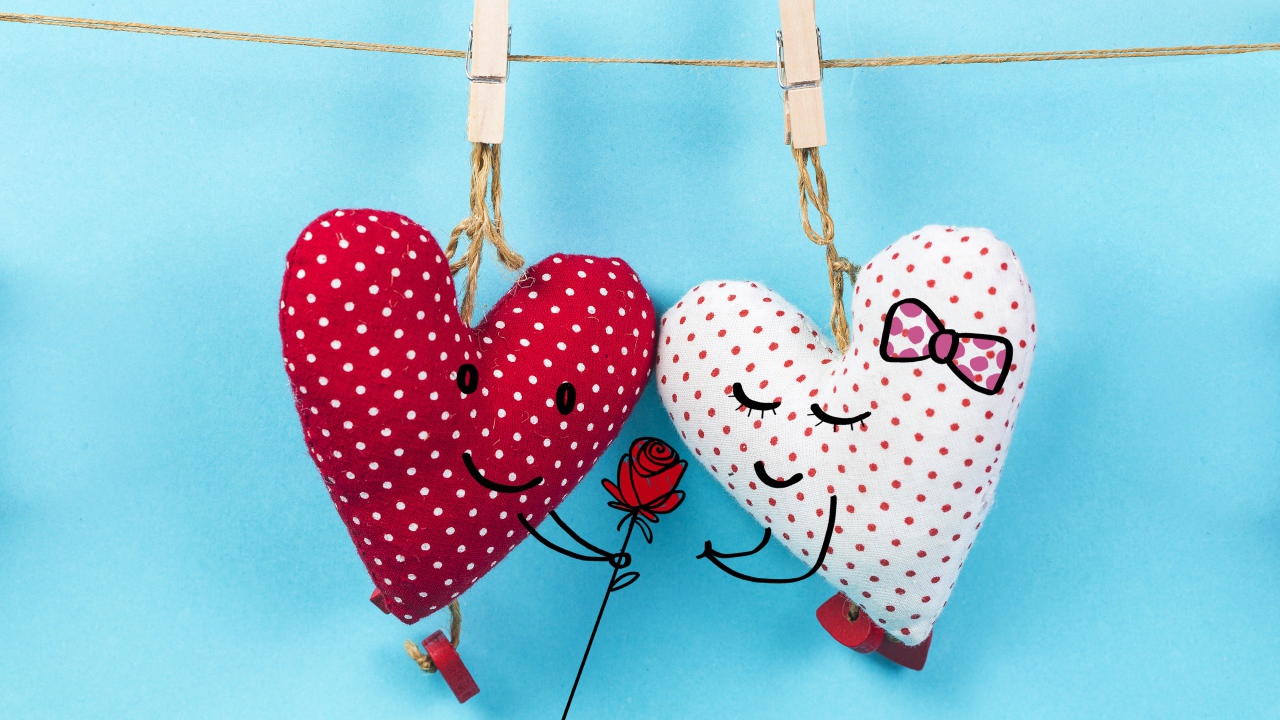Два сердечка на прищепках на веревке на голубом фоне