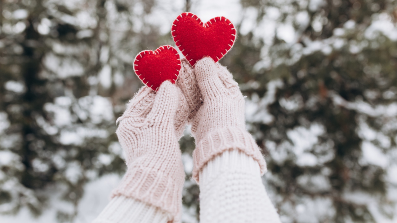 Два красных сердечка из ткани в руках у девушки 