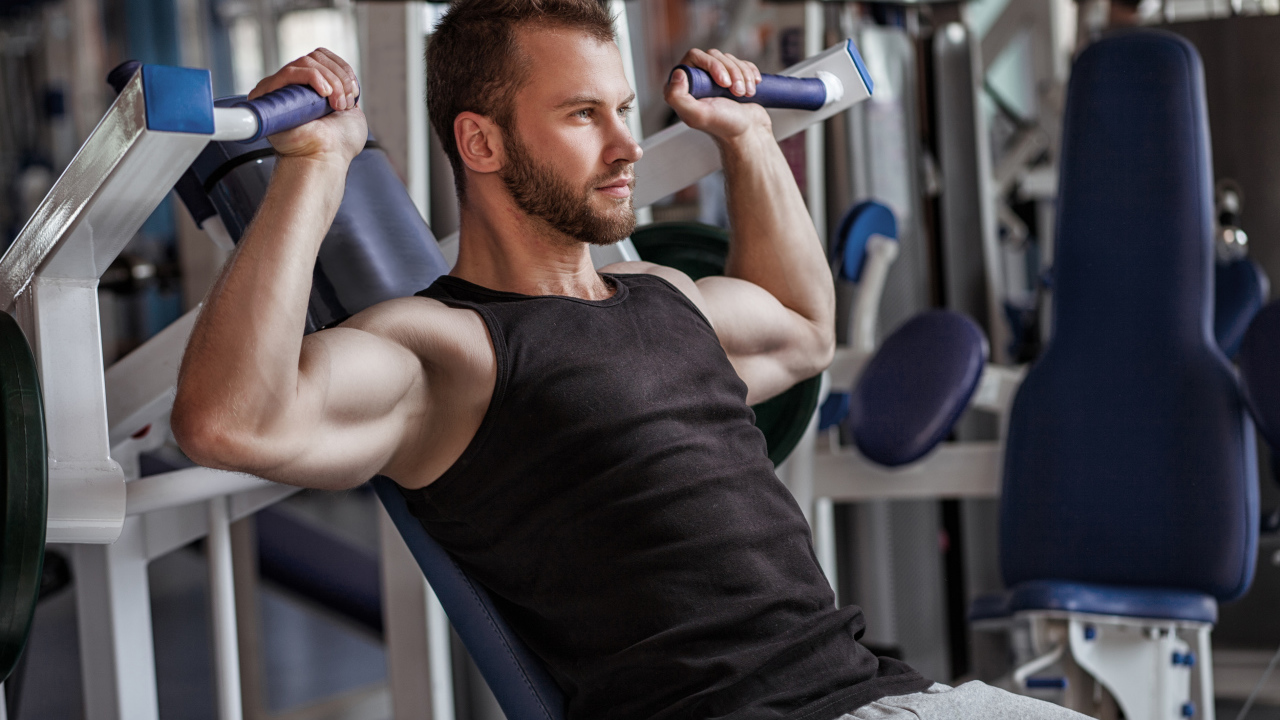 Накаченный мужчина занимается в спортзале