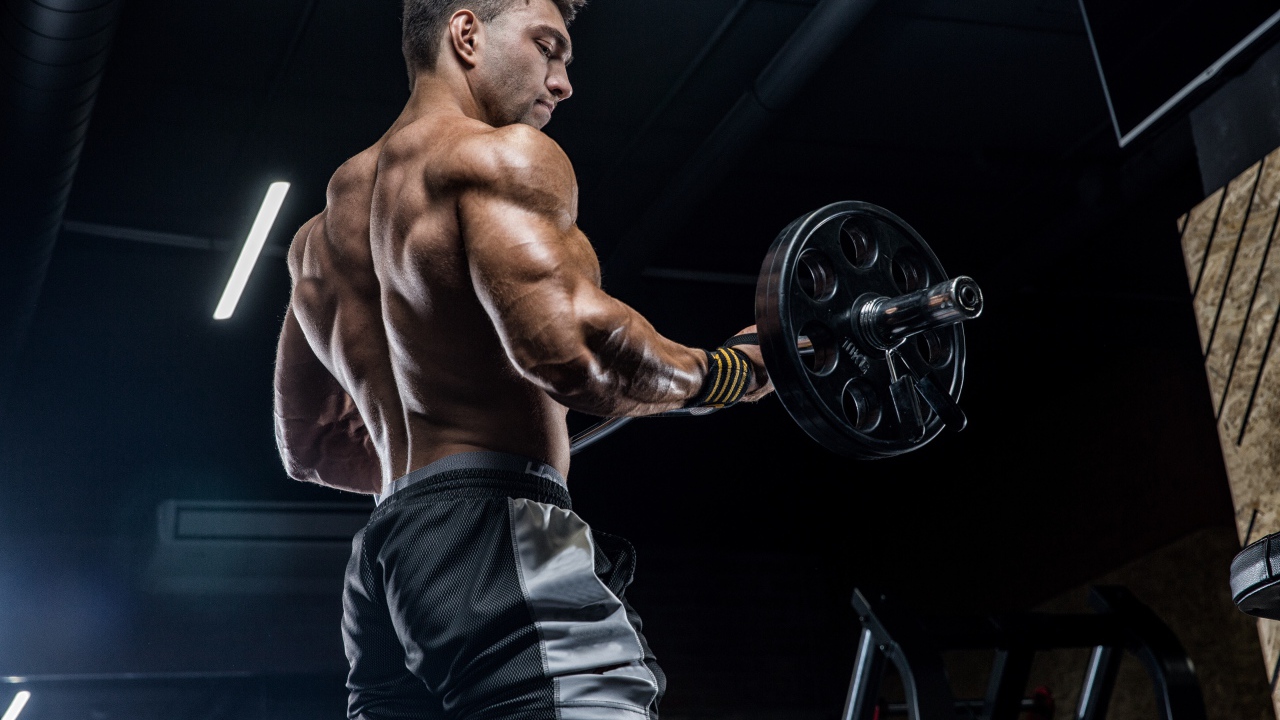 Спортивный накаченный мужчина со штангой в руках 