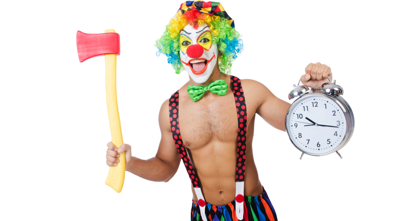 Мужчина  в костюме клоуна с топором и часами в руке на белом фоне