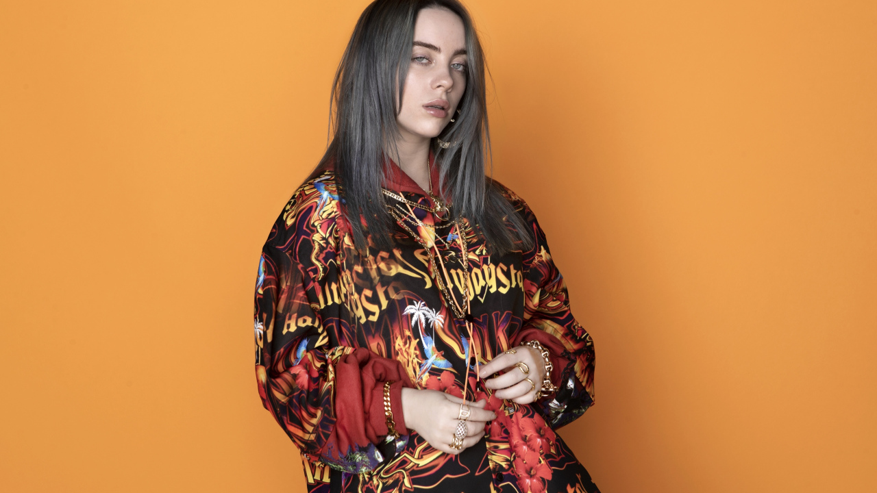 Певица Билли Айлиш на оранжевом фоне