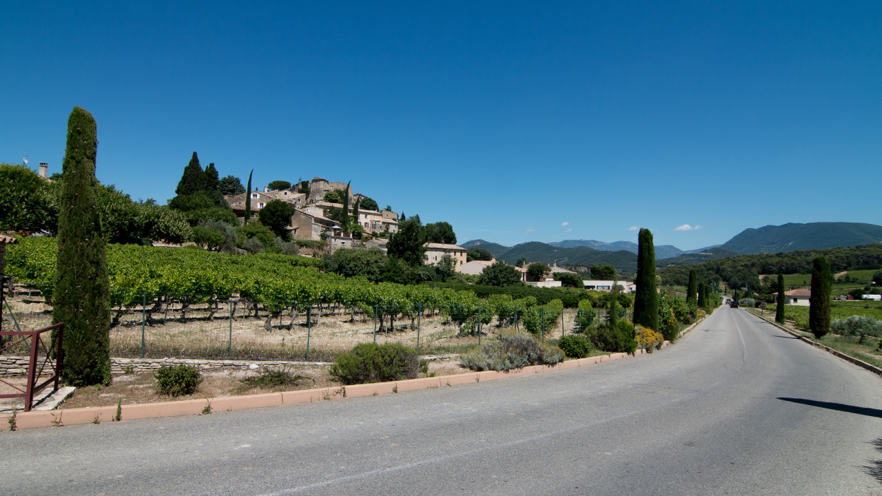 Асфальтовая дорога у большого дома под голубым небом
