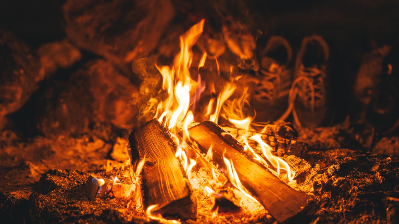 Дрова лежат в ярком огне костра