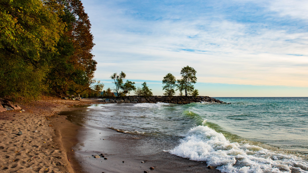 Белые волны океана на мокром песке под красивым небом