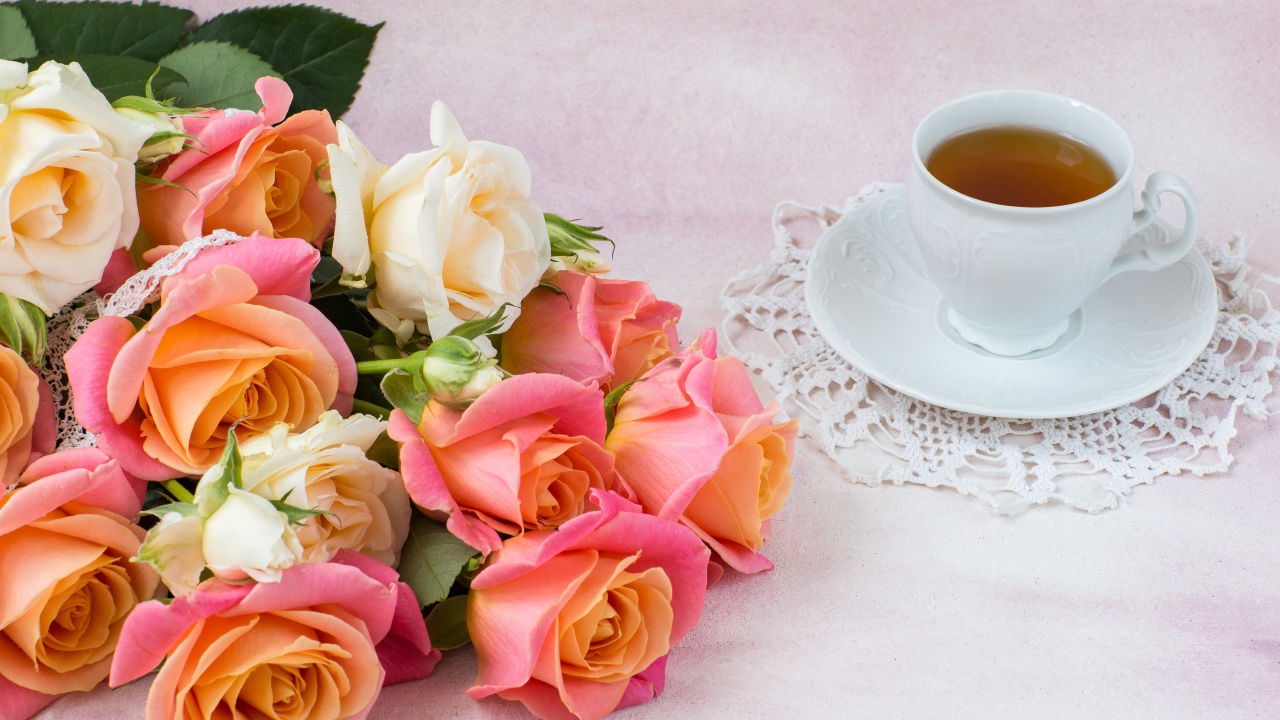 Красивый букет нежных роз на столе с чашкой чая