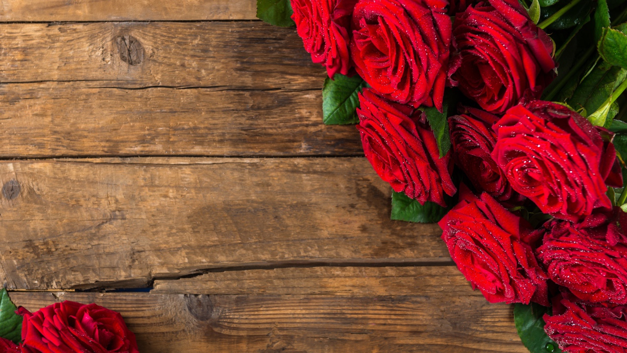 Красивый букет красных роз на деревянном фоне