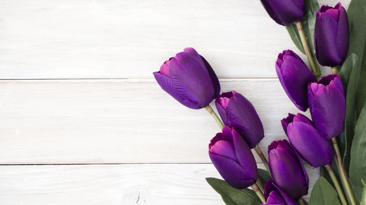 Букет искусственных фиолетовых тюльпанов на деревянном фоне