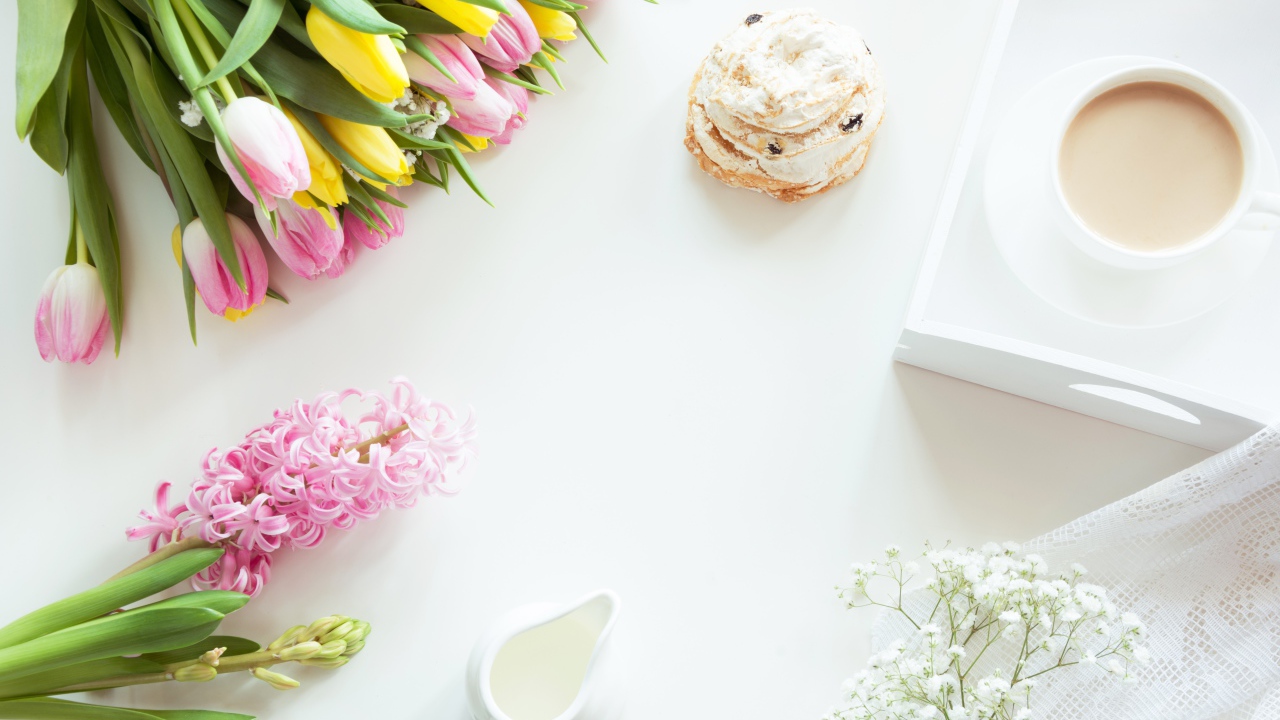 Букет тюльпанов и гиацинт на столе с пирожным и чашкой какао 