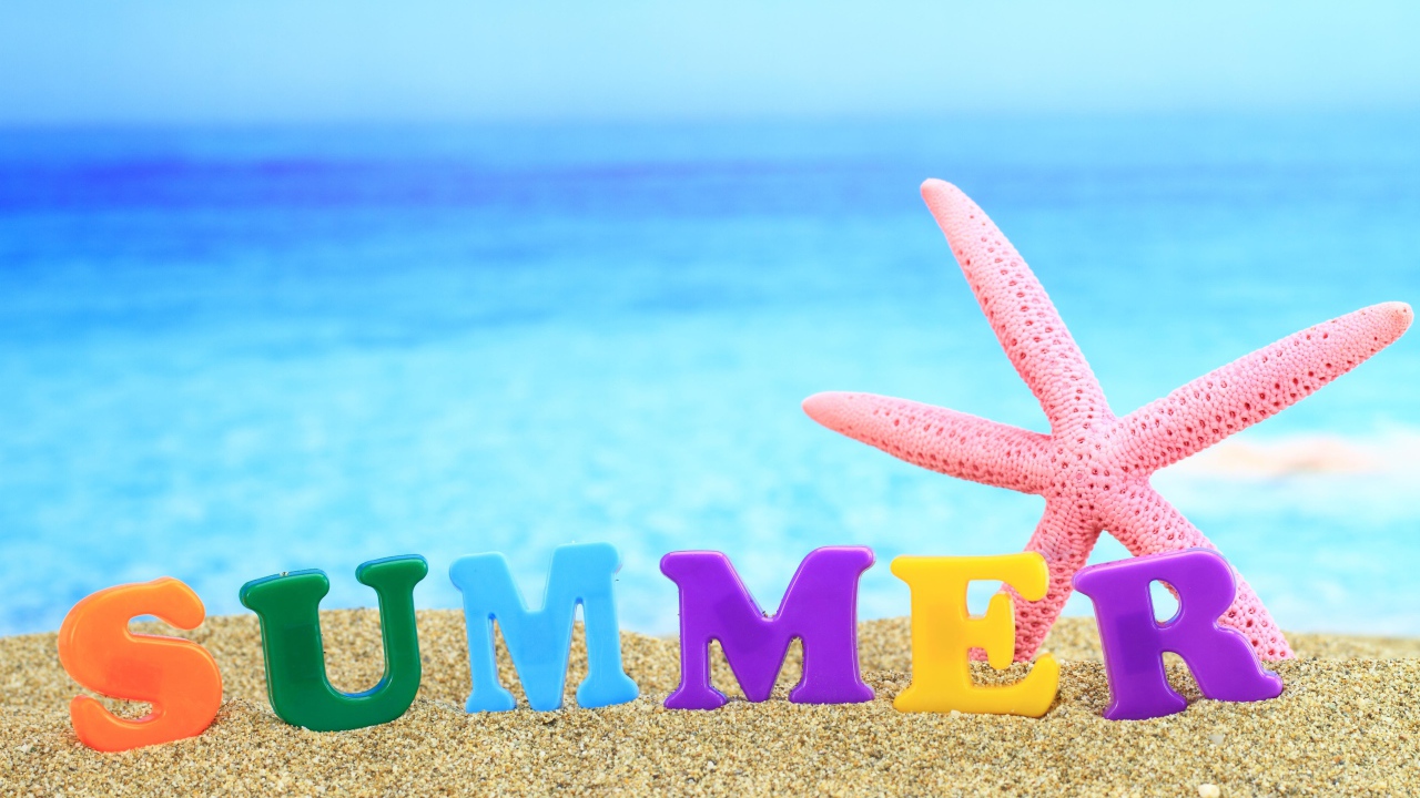 Розовая морская звезда и надпись лето на английском на песке