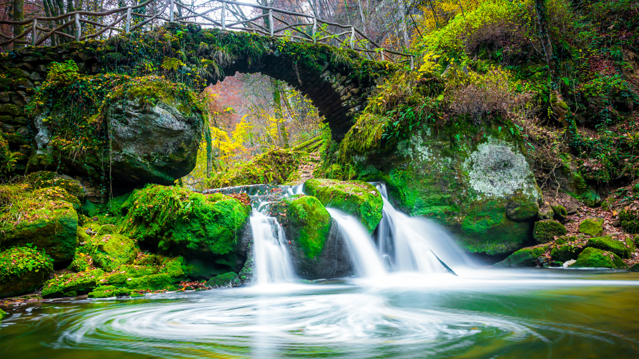Водопад под старым покрытым мхом мостом