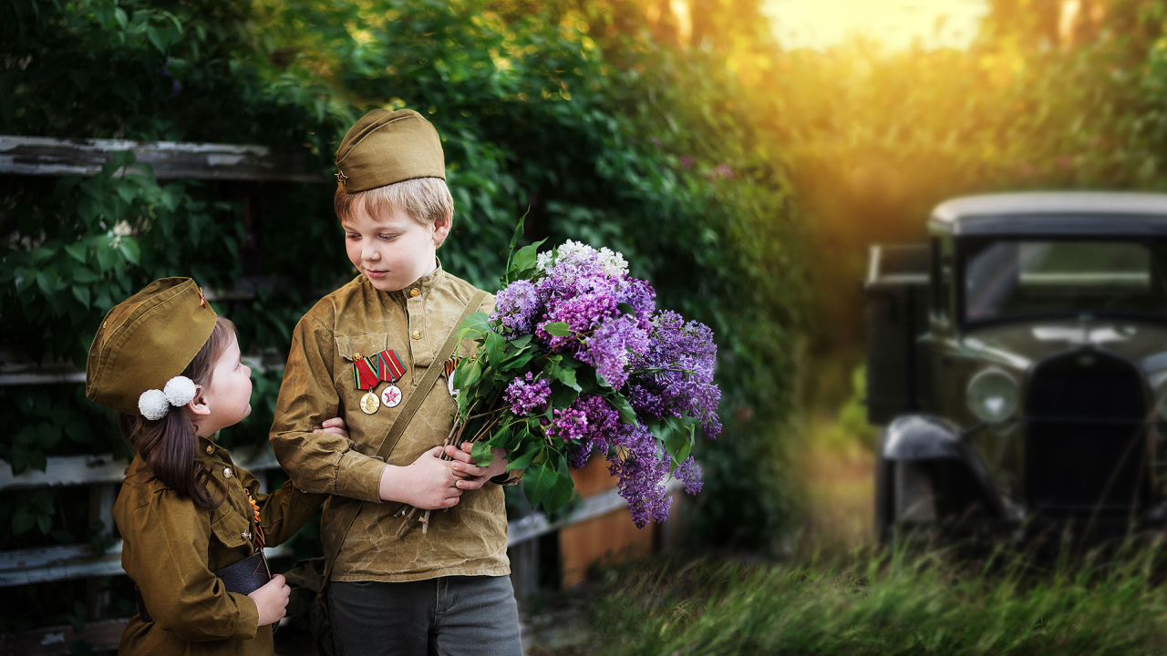 Маленький мальчик с девочкой в военной форме с букетом сирени на 9 мая 