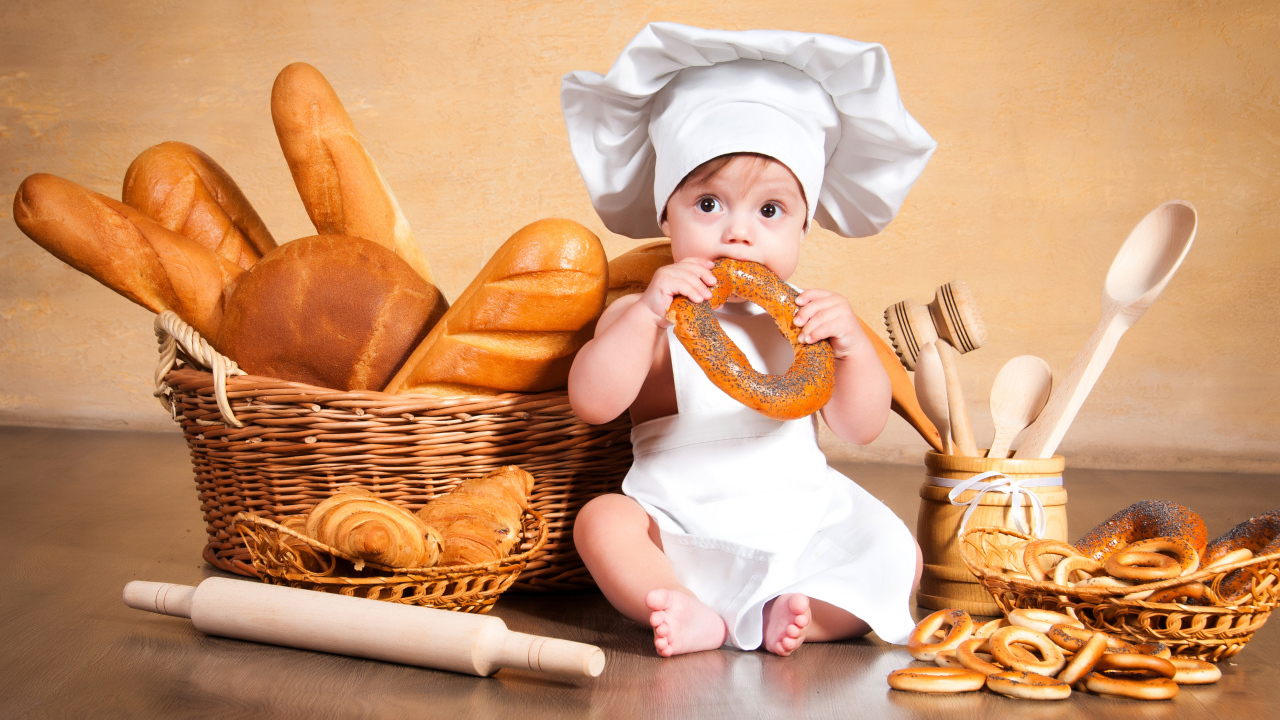 Маленький мальчик с хлебобулочными изделиями на столе 