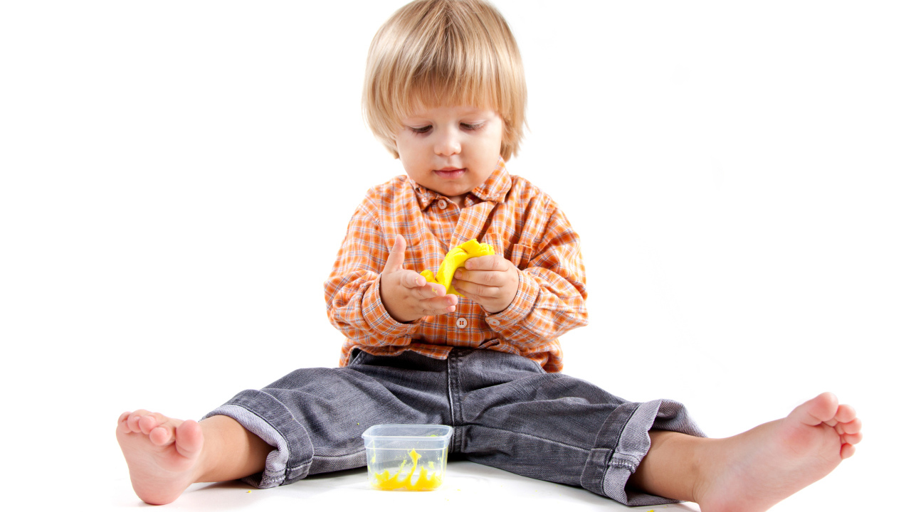 Маленький мальчик с игрушкой на белом фоне