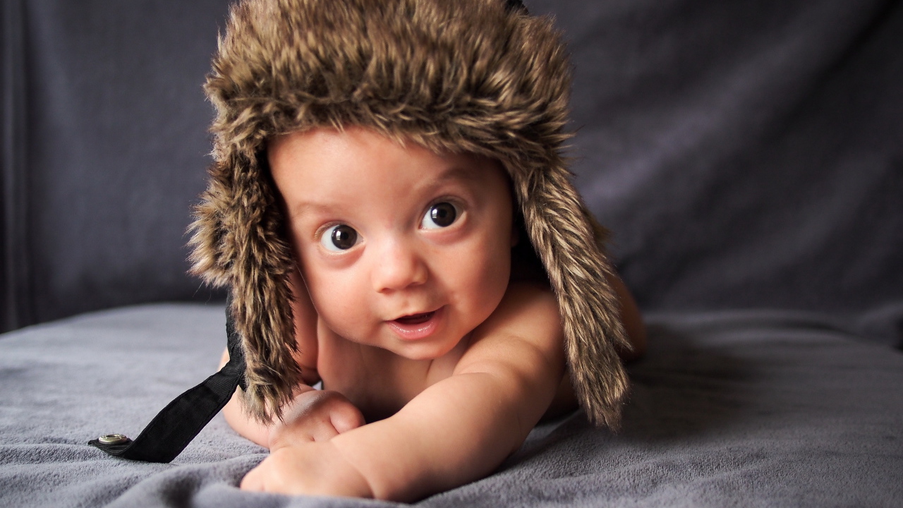 Маленький кареглазый ребенок в теплой шапке