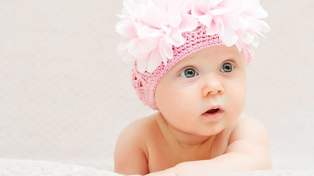 Маленькая девочка в вязаной шапке с цветами