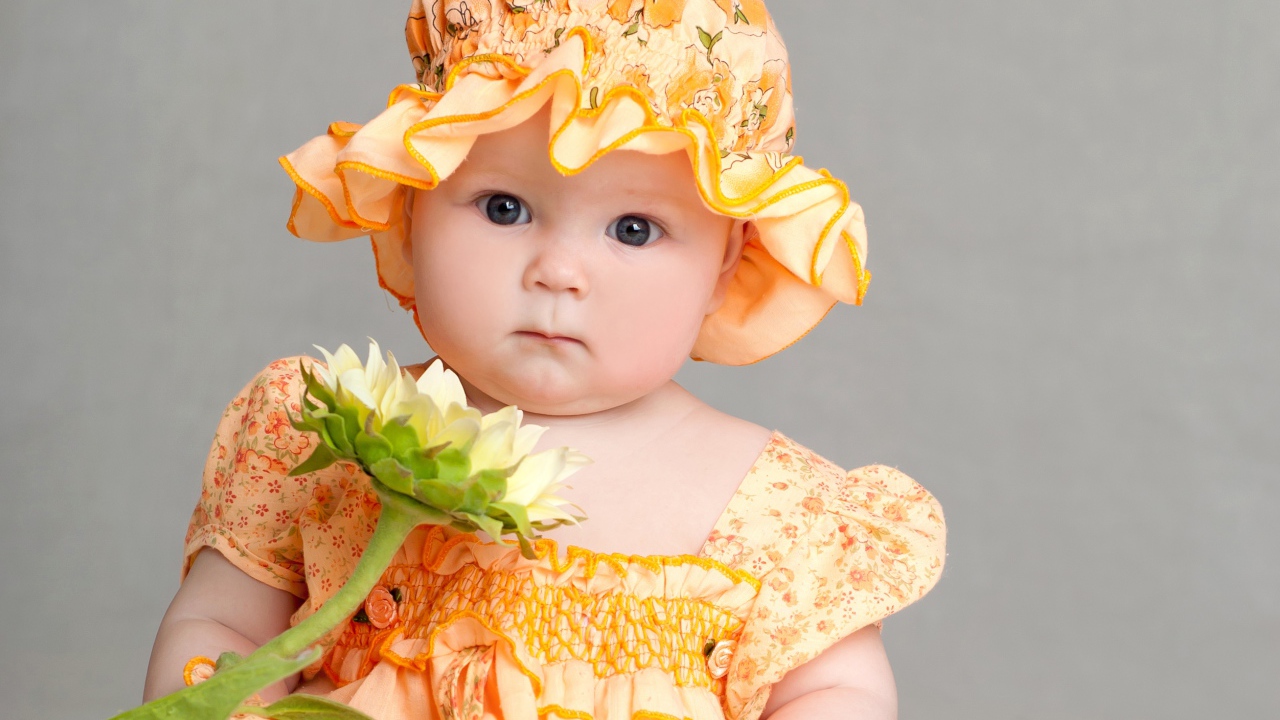 Маленькая девочка в красивом наряде с цветком