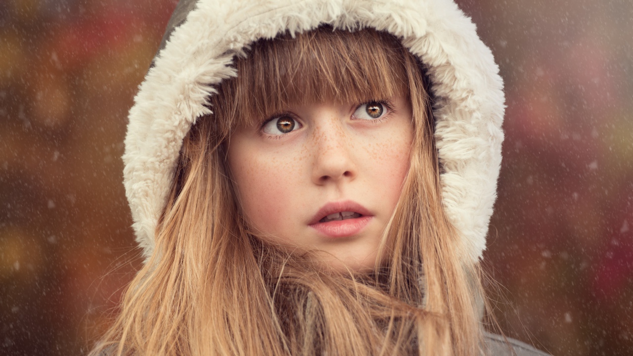 Маленькая девочка с веснушками на лице в капюшоне 