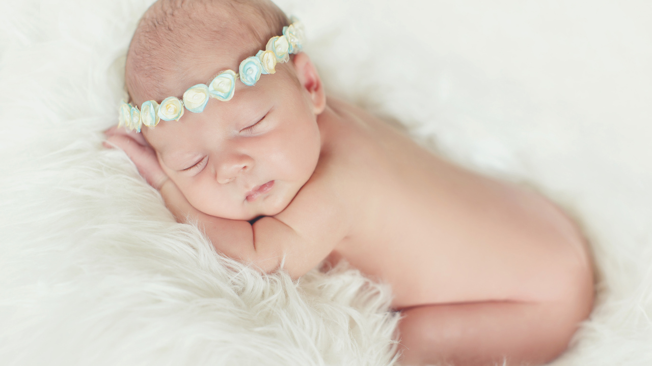 Маленький спящий ребенок на меховом покрывале