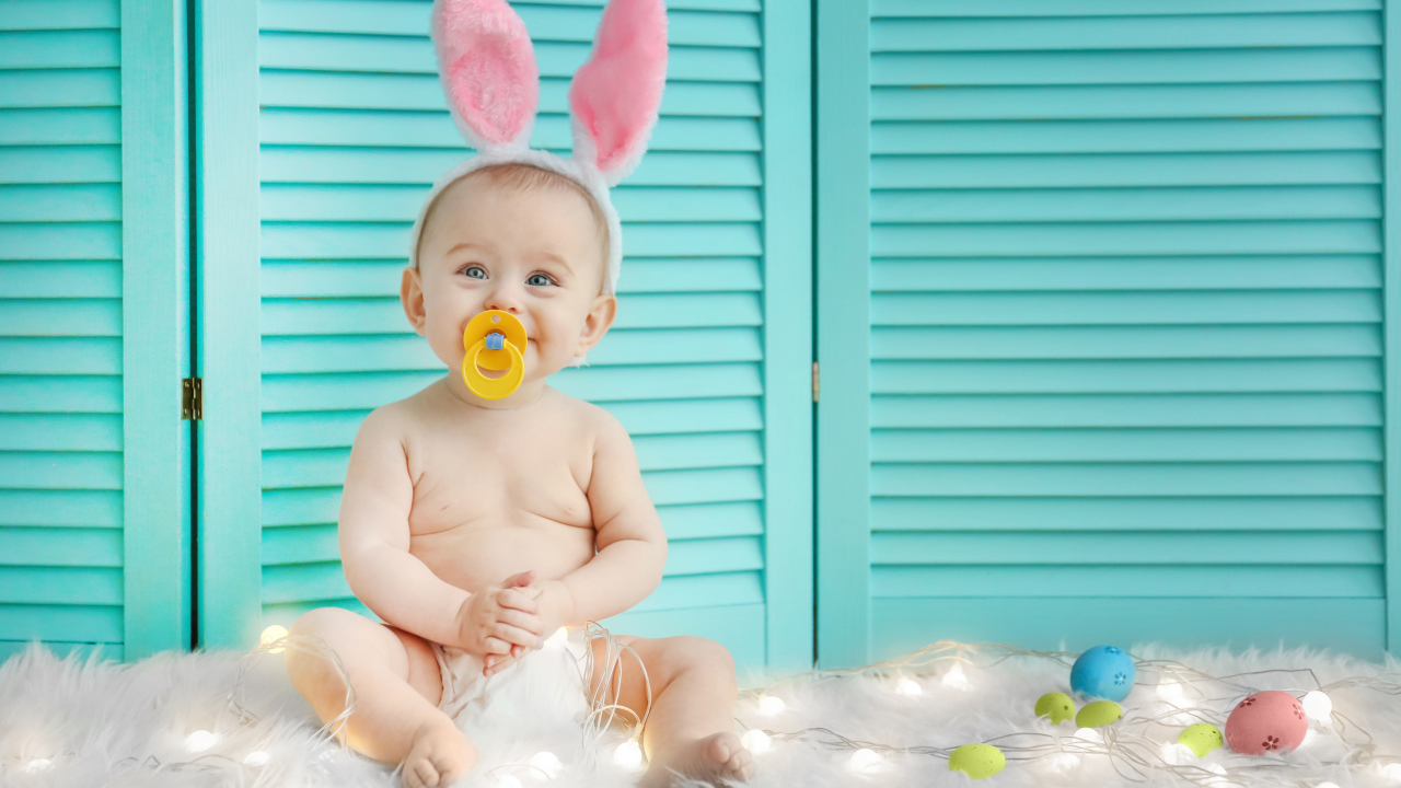 Маленький улыбающийся малыш с ушками зайчика на голове