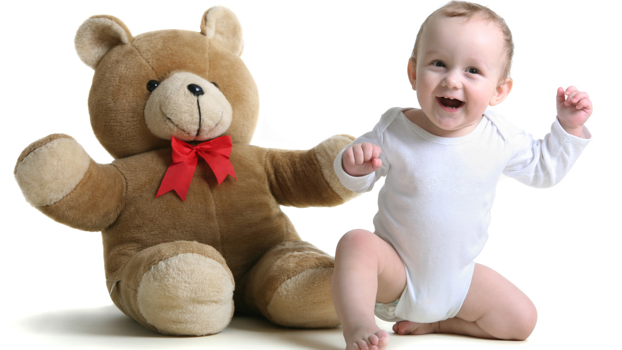 Улыбающийся малыш в большим игрушечным медведем