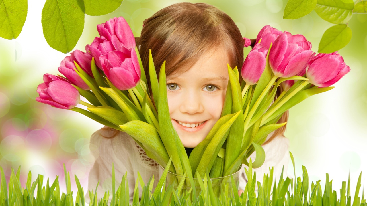 Улыбающаяся маленькая девочка с розовыми тюльпанами