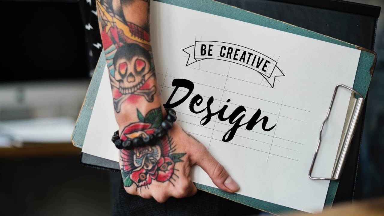 Мужчина с татуировкой на руке держит папку