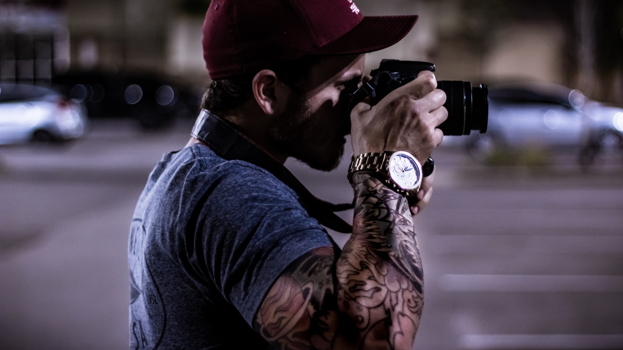 A man with a tattoo on his hand makes a photo