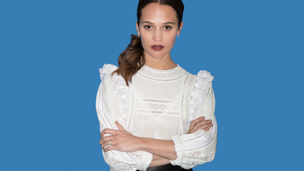 Актриса Алисия Викандер в белой блузке на синем фоне