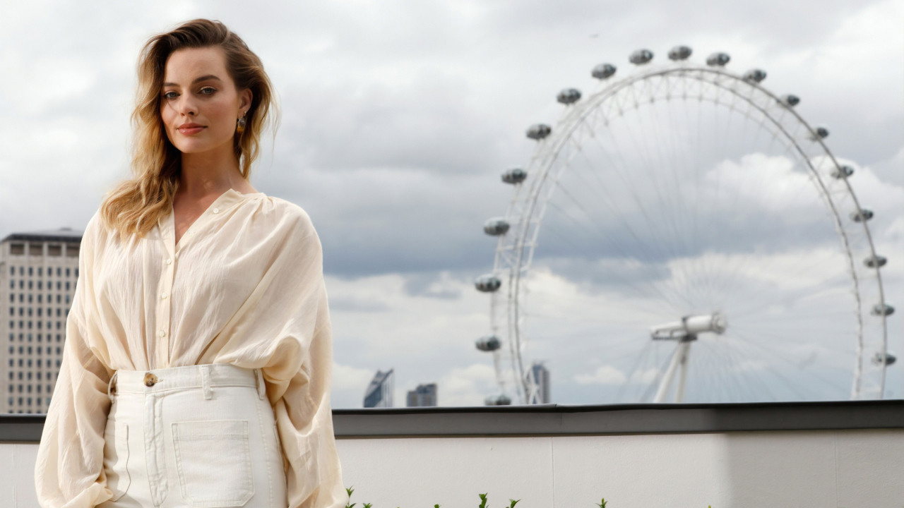 Актриса Марго Робби на  фоне аттракциона  колесо обозрения