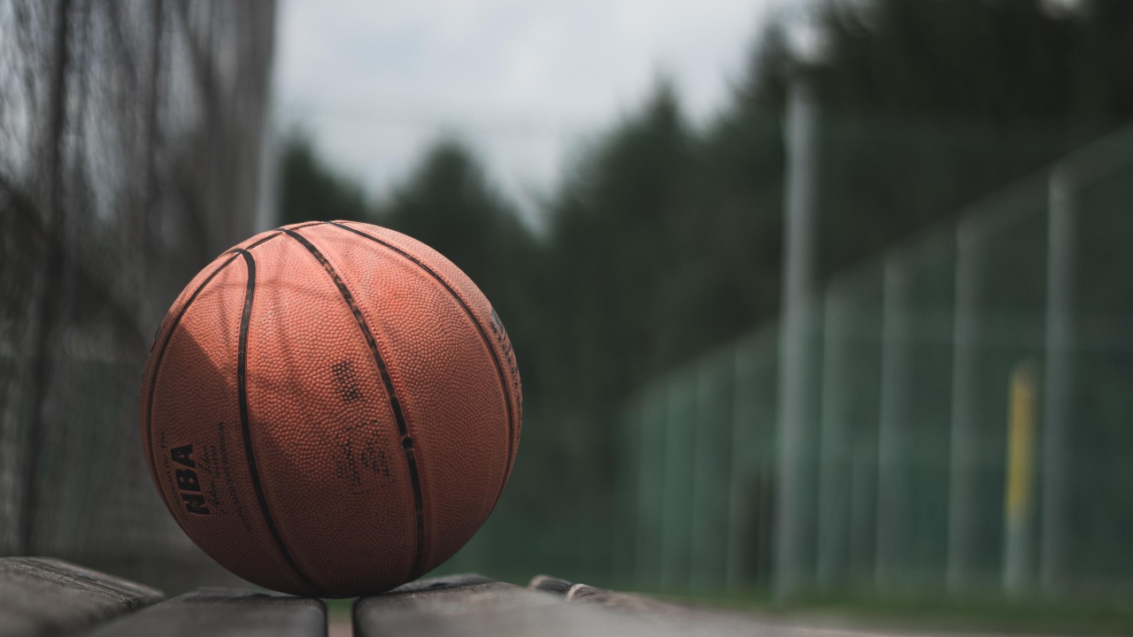 Баскетбольный мяч лежит на деревянной лавке