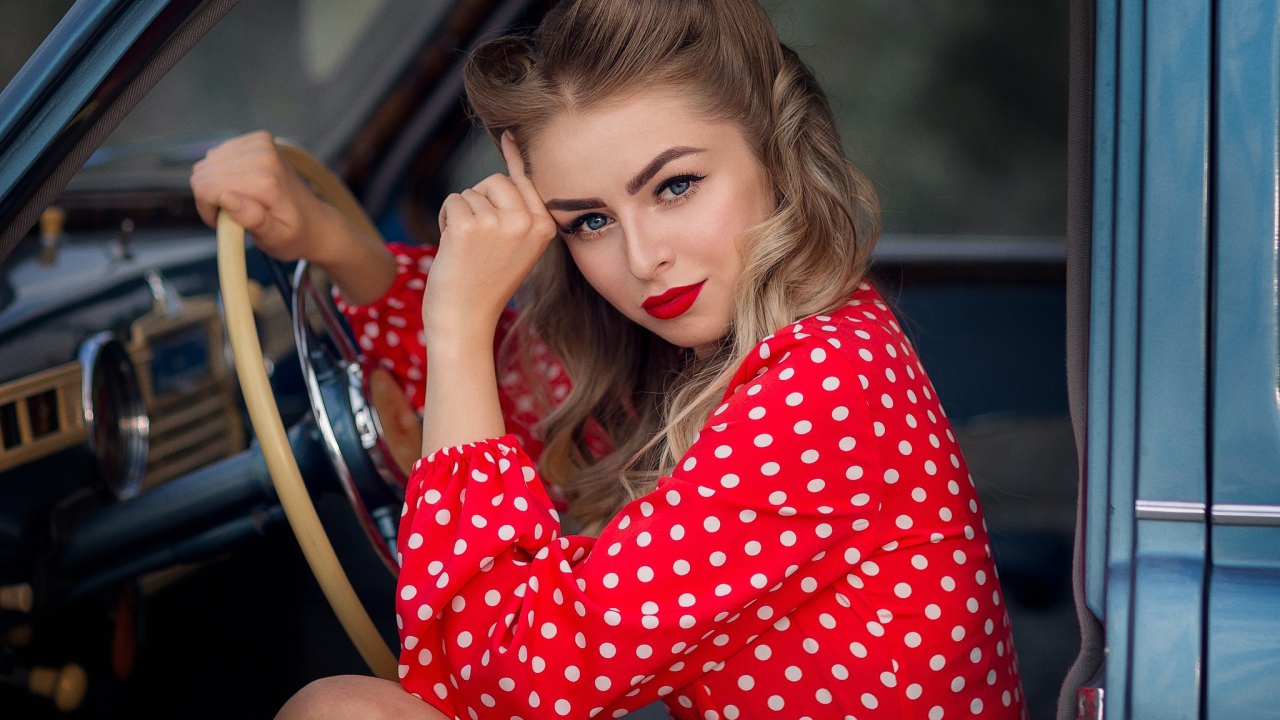 Голубоглазая ретро девушка за рулем автомобиля 