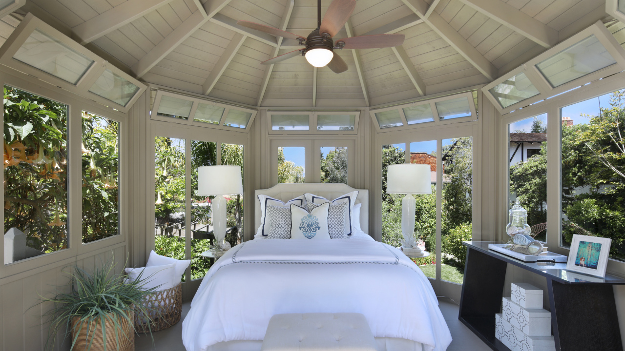 Большая спальная комната с окнами и белой кроватью 