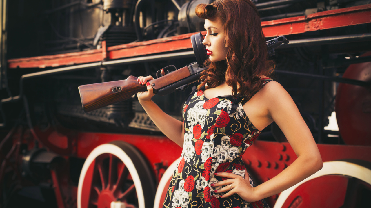 Девушка ретро с автоматом в руке  у тепловоза 