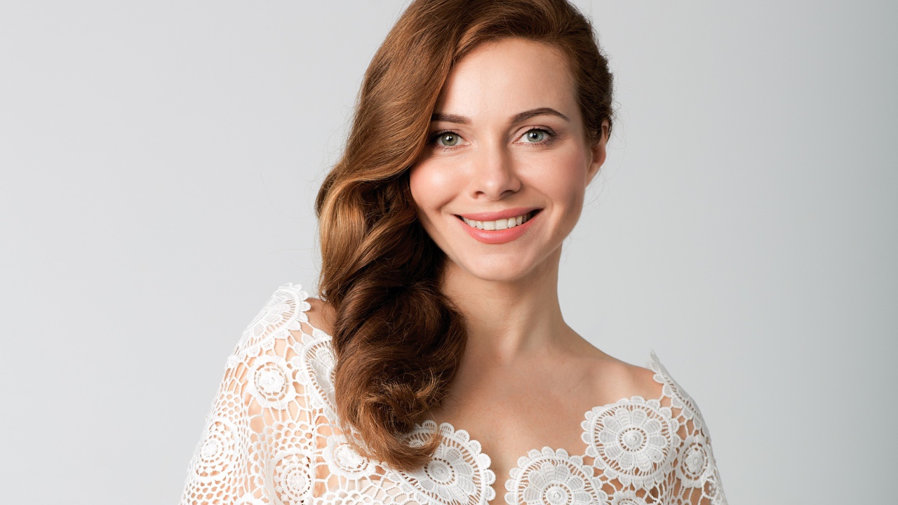 Улыбающаяся милая девушка, актриса Екатерина Гусева на сером фоне