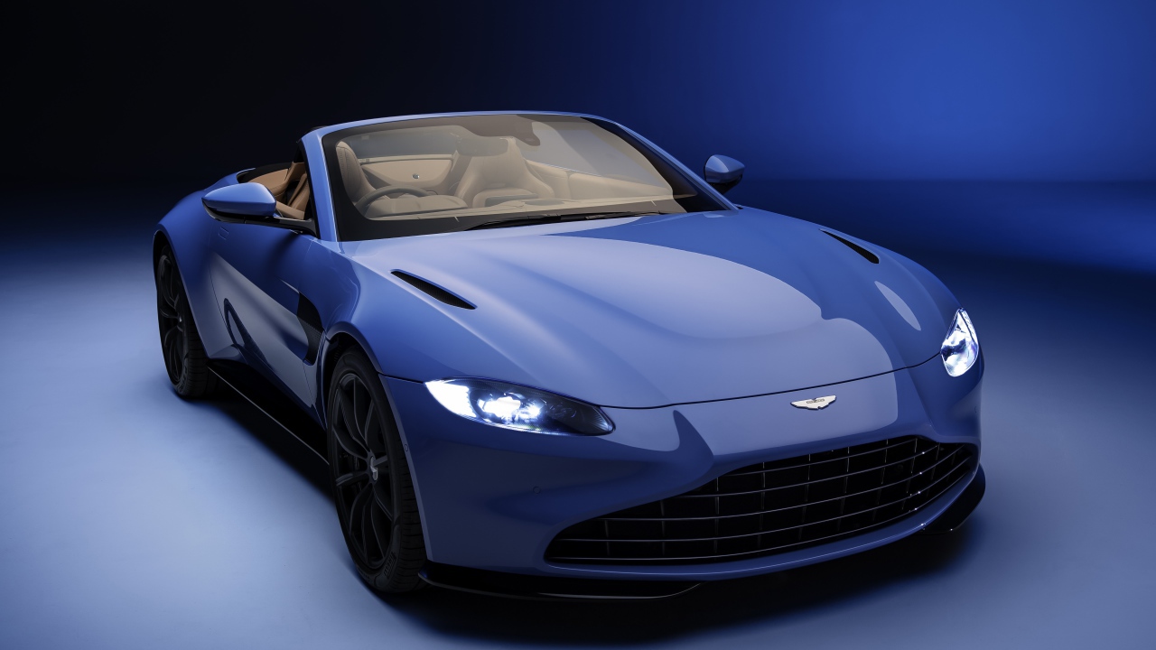 Кабриолет Aston Martin Vantage Roadster 2020 года на синем фоне