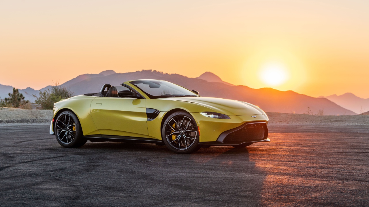 Желтый автомобиль  Aston Martin Vantage Roadster, 2021 года на закате