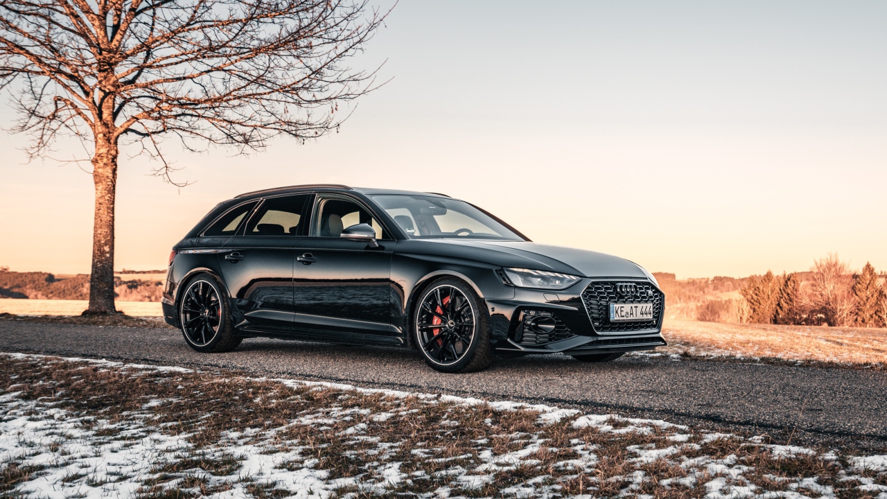 Черный автомобиль  Audi RS 4 Avant 2020 года на дороге у дерева