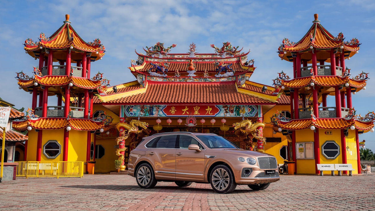 Коричневый автомобиль Bentley Bentayga V8 2020 года на фоне красивого здания