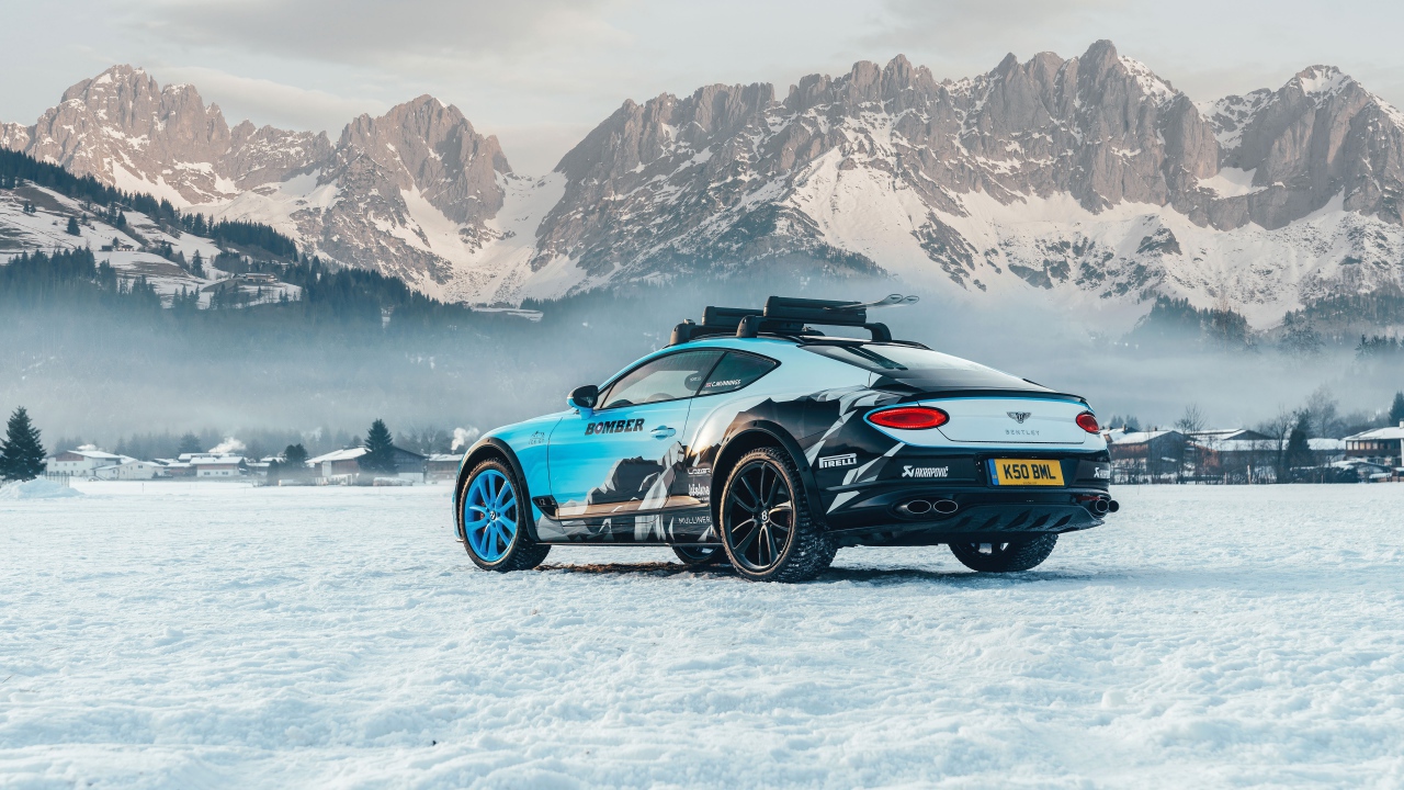 Автомобиль bentley continental gt, 2020 года на фоне заснеженных гор 