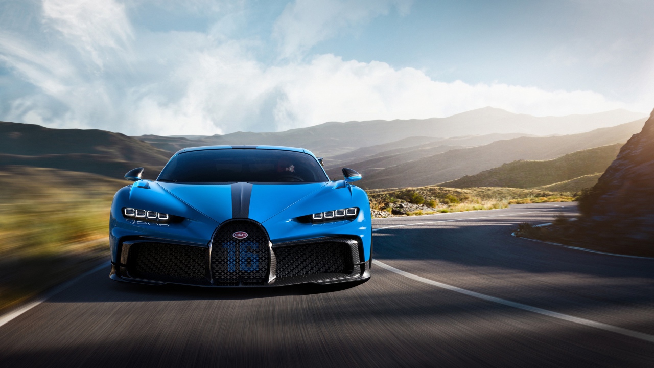 Синий автомобиль Bugatti Chiron Pur Sport 2020 года на трассе в горах 